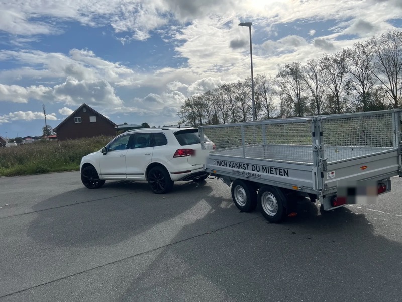 Kippanhänger am Auto angekuppelt, schräg von hinten, Schriftzug „Mich kannst du mieten“ und mietservice-brake.de